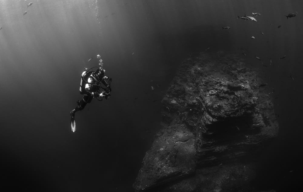 grayscale photo of person scuba diving